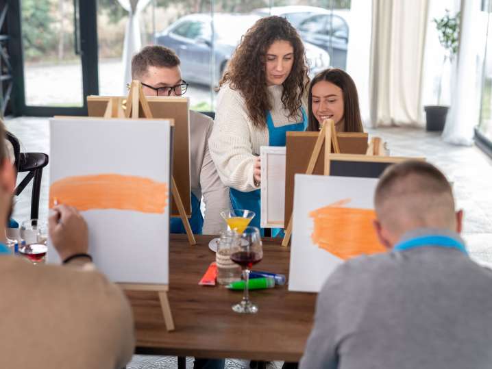 Portland - Group of adults painting at easels during a guided paint and sip class Shot