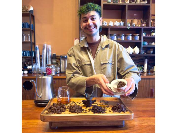 Portland - Tea guide demonstrating gongfu brewing with a tray of assorted teas in a tea shop Shot