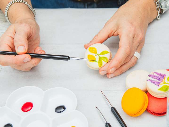 Online - a woman painting macarons by hand Shot