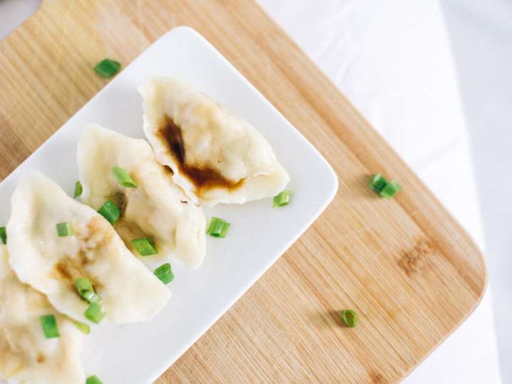 Cleveland - Steamed dumplings served on a rectangular white plate, garnished with chopped scallions Shot