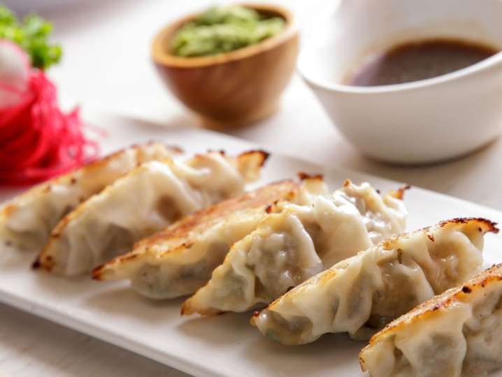 Tulsa - A platter of crispy pan-fried dumplings served with dipping sauce and pickled ginger Shot