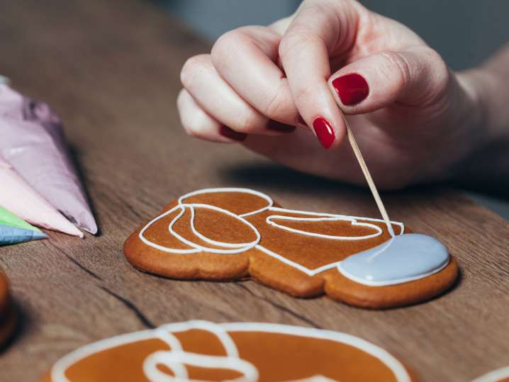 Boston - Hands piping white icing onto a decorated sugar cookie Shot