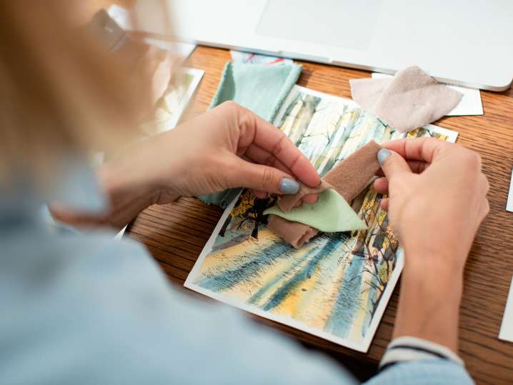 Boston - Hands assembling a travel-themed postcard using printed photos and paper cutouts Shot