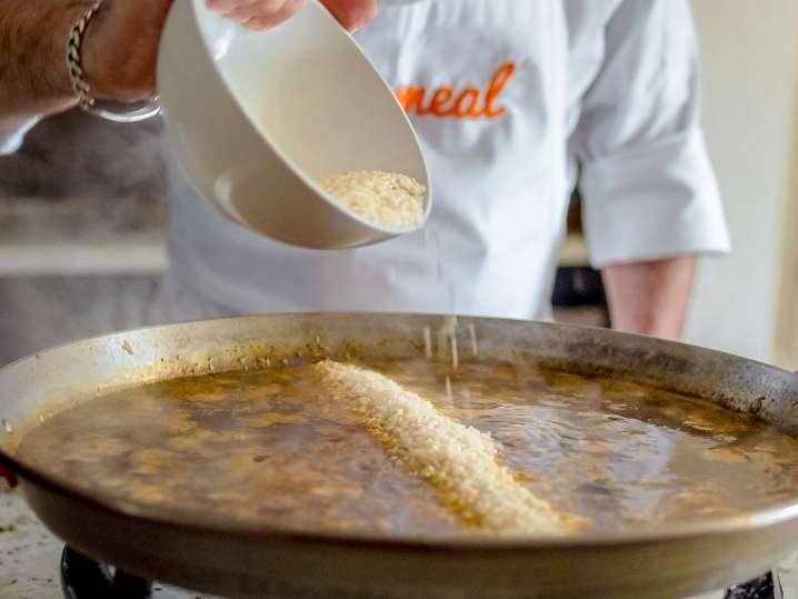 chef adding rice to pan to make paella | Classpop Shot