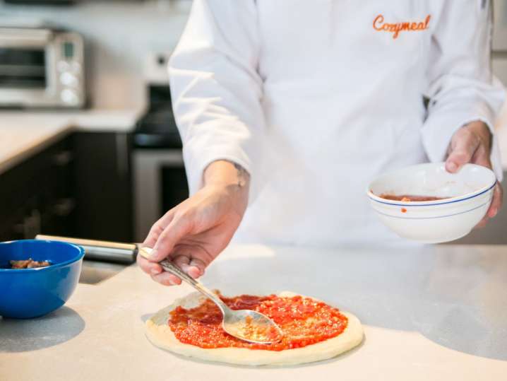 puttin tomato sauce on pizza dough | Classpop Shot