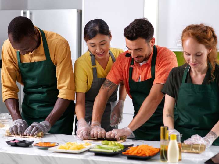 team preparing sushi rolls together | Classpop Shot