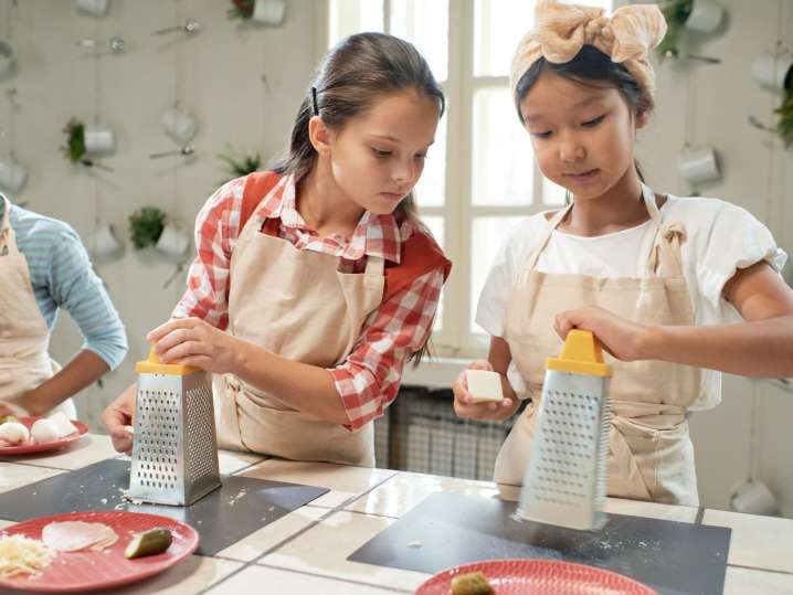 group of girls are grating cheese for pizza | Classpop Shot