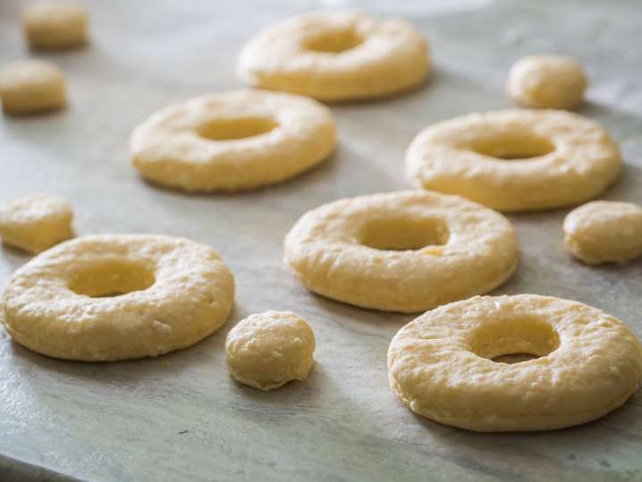 doughnuts and doughnut holes proofing on a baking sheet Shot