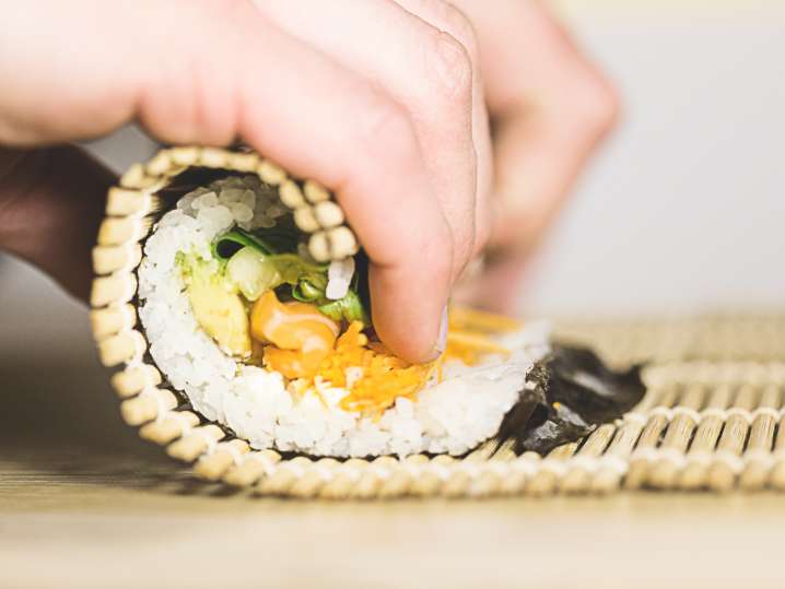 chef rolling sushi with a bamboo mat Shot