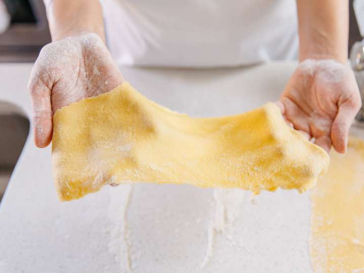chef's hands holding sheet of fresh pasta dough Shot