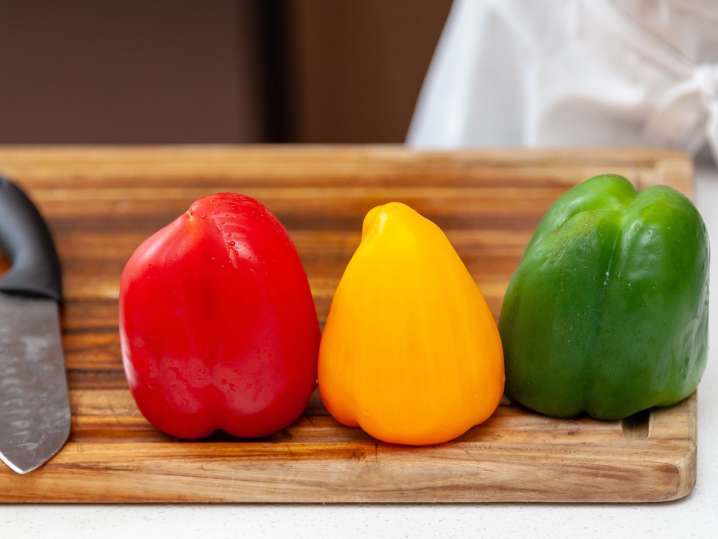 trio of bell peppers lined up on a cutting board Shot