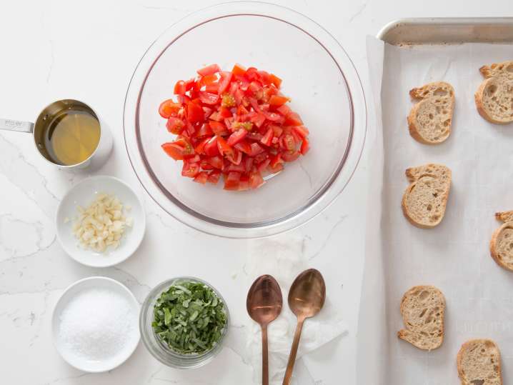 tomatoes, cheese, and bread on a table for making bruschetta Shot
