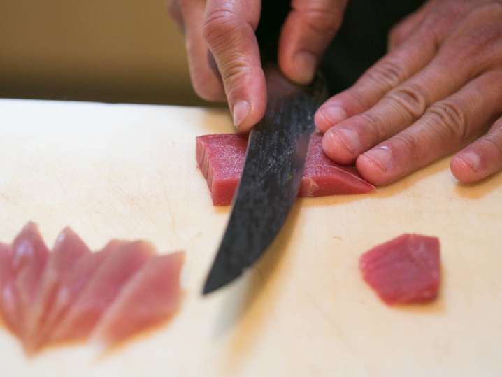 chef's hands slicing fresh tuna Shot