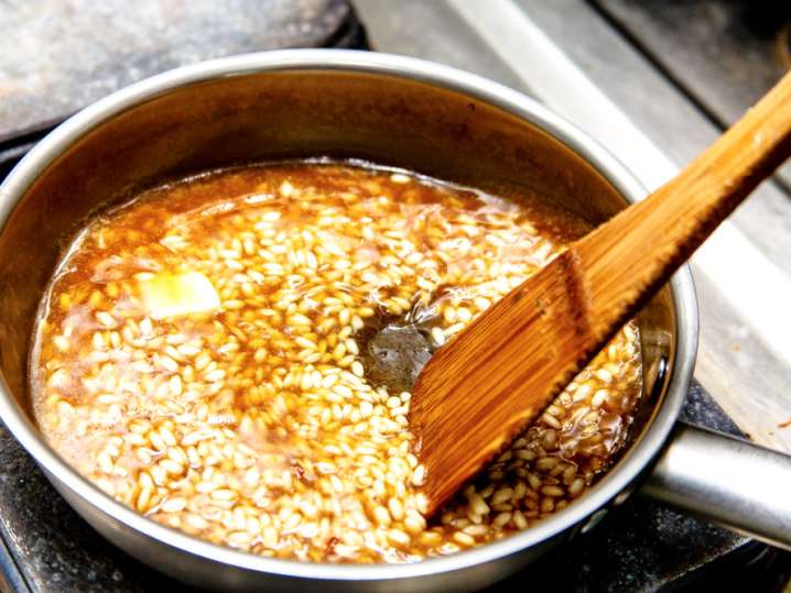 stirring risotto in a pan with butter Shot