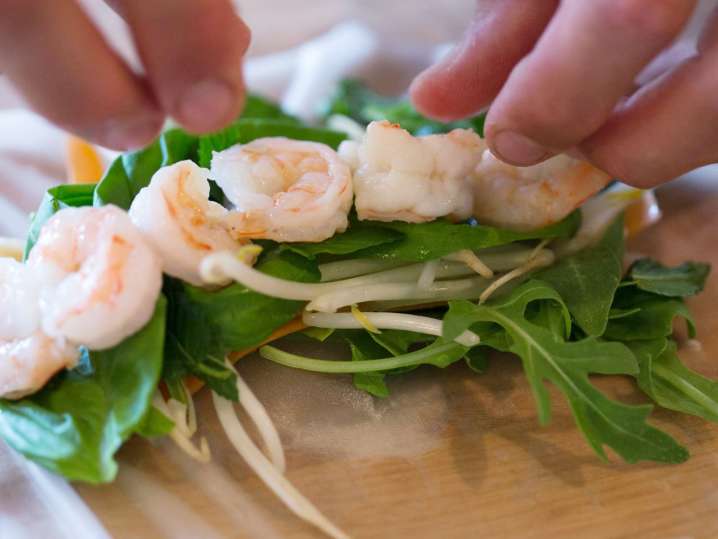 chef wrapping shrimp and vegetables in a rice paper wrapper Shot