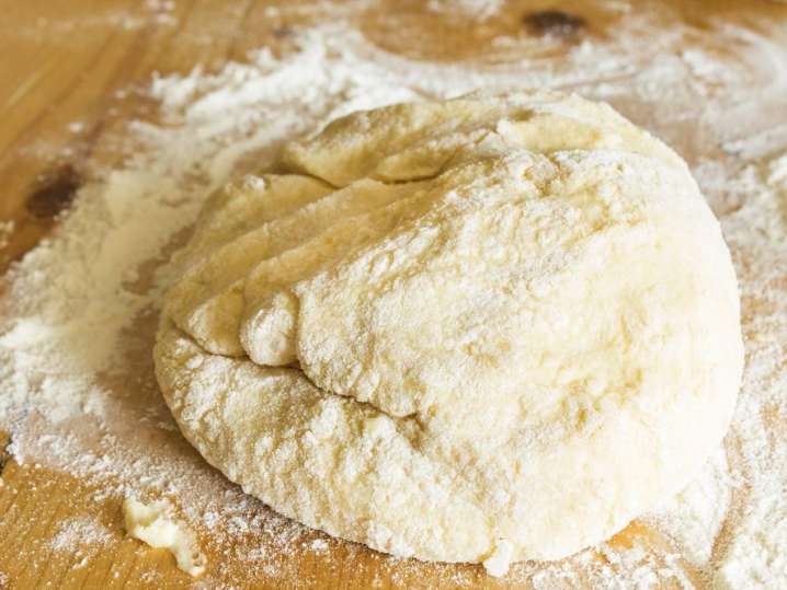 homemade pasta dough ball on a floured work surface Shot
