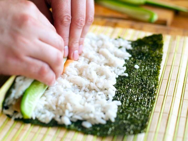 chef rolling sushi on a bamboo mat Shot