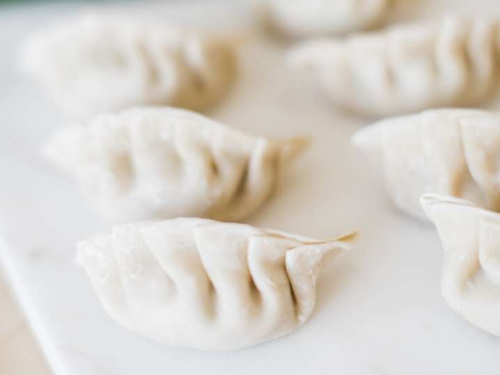 uncooked pot stickers on a cutting board Shot