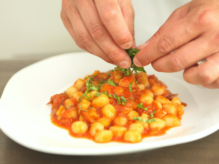 Chef garnishing plate of gnocchi Cozymeal | Classpop Shot