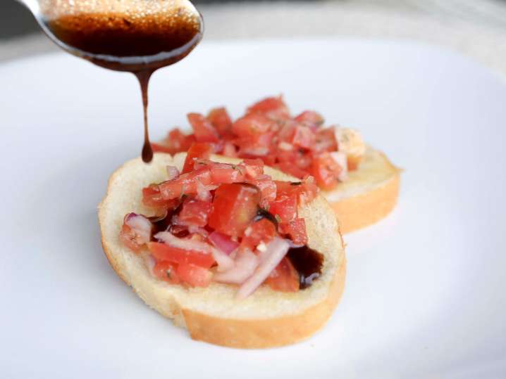 chef drizzling balsamic on bruschetta | Classpop Shot