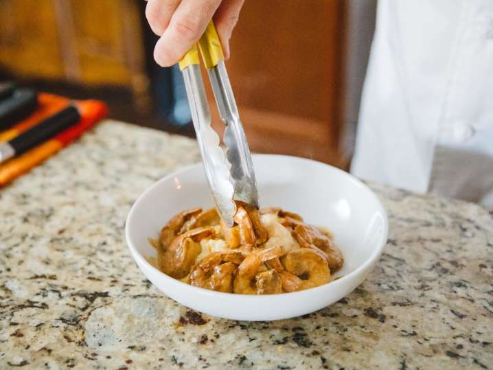 Chef completing plate of shrimp and grits | Classpop Shot