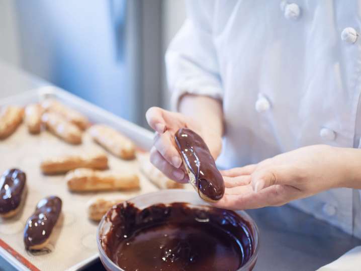 chef presenting freshly piped eclair | Classpop Shot