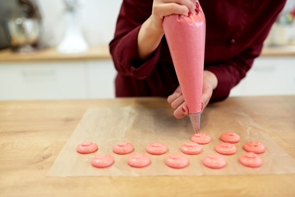 Boston - cooking-baking-people-concept-chef-with-confectionery-bag-squeezing-macaron-batter-meringue-cream-baking-paper-pastry-shop-kitchen Shot 1