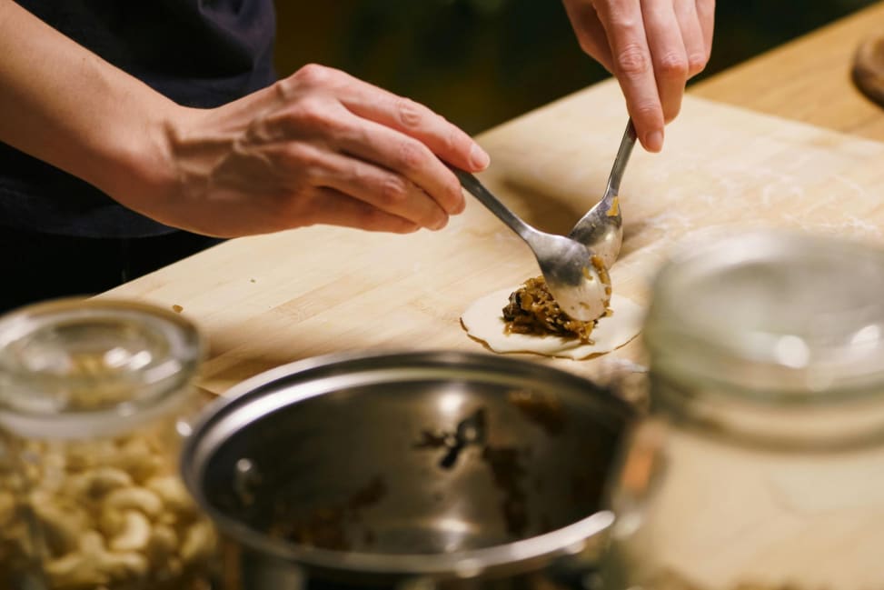 Bay Area - Close-up of preparing savory pierogi filling beside dough rounds Shot 1