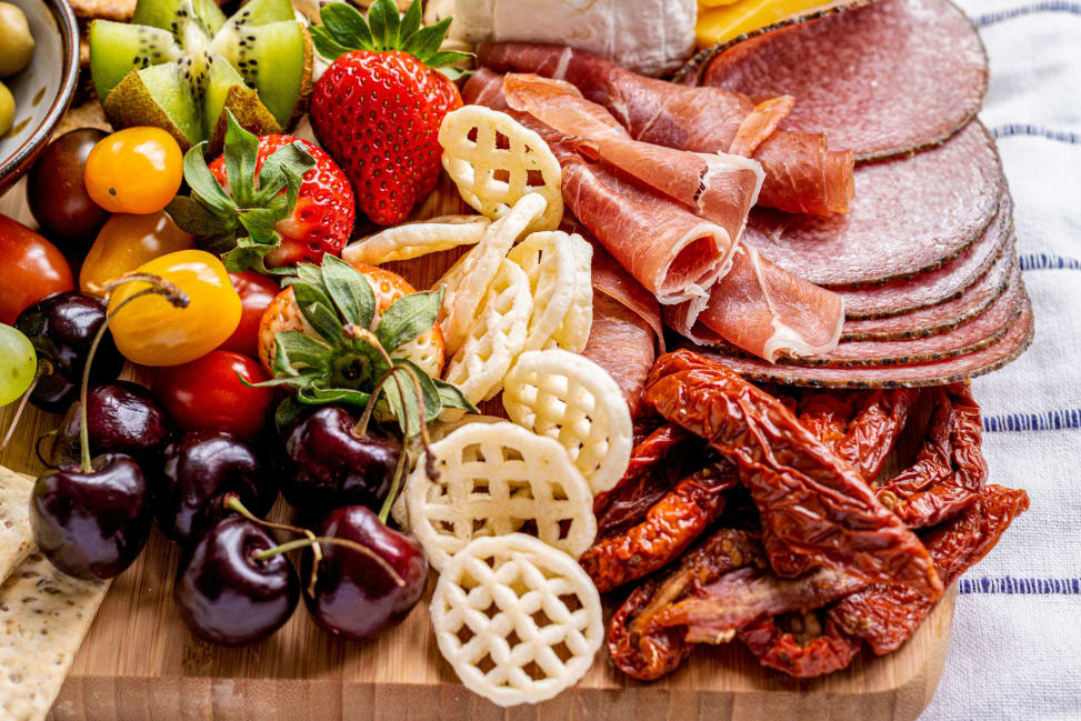 Bay Area - Rustic charcuterie board featuring salami, cured meats, fresh fruit and crunchy snacks Shot 1