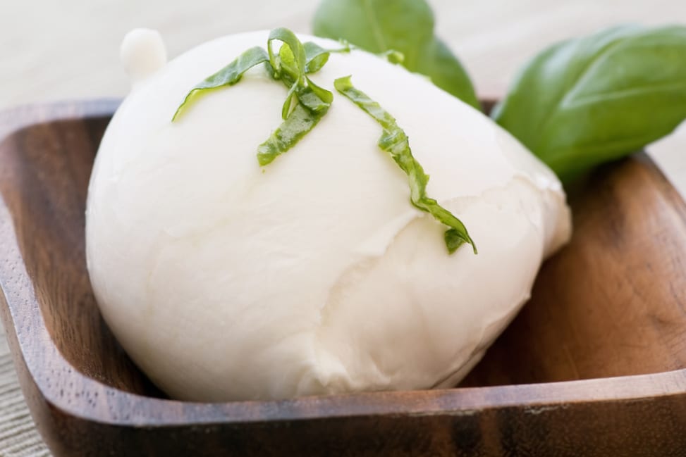 ball of mozzarella in a bowl with fresh basil Shot 2