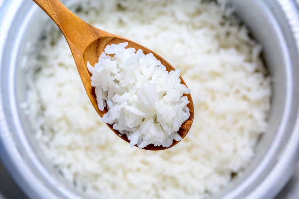 spoon full of basmati rice over a rice cooker Shot 2