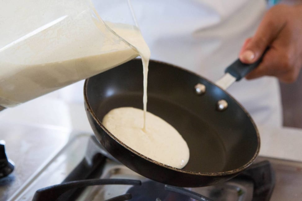 chef pouring crepe batter into a frying pan Shot 1