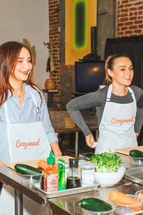 Women learning a new recipe in a hands-on girls night out cooking class