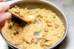 chef's hand stirring mushroom risotto with a wooden spoon Shot