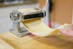 chef rolling a sheet of fresh pasta dough Shot