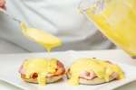 Los Angeles - drizzling homemade hollandaise onto parma ham and english muffins Shot