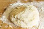 homemade pasta dough ball on a floured work surface Shot