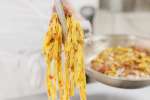 chef plating homemade pappardelle and bolognese sauce Shot