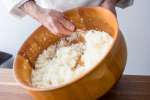 chef stirring sushi rice in a bamboo bowl Shot