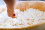 chef stirring sushi rice in a bamboo bowl Shot