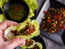 Cooking Class - Scallion Pancakes to Beef Bulgogi in Downtown Dallas: Hand assembling a lettuce wrap with beef and dipping sauce in the background.