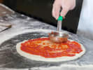 Online Cooking Class - Homemade Gluten-Free Pizza: Spooning sauce on gluten-free pizza