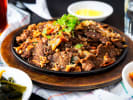 Cooking Class - A Korean BBQ Masterclass in Northern Suburbs: Bowl of grilled bulgogi beef garnished with scallions and sesame seeds.