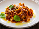 Cooking Class - The Path to Pasta Mastery in Northern Suburbs: Pappardelle pasta with rich Bolognese sauce, garnished with basil.