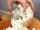 Cooking Class - Ultimate Southern Comfort Feast in Downtown Dallas: Hands chopping fresh cauliflower florets on a wooden cutting board.