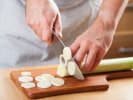 Cooking Class - An Aromatic French Feast in Downtown Dallas: Slicing leeks on a wooden cutting board.