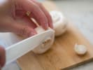 Cooking Class - Italian Small Plates in Downtown Dallas: A close up of hands slicing fresh white mushrooms on a wooden board