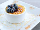 Private Chef - Delightful Steakhouse Fare: A dish of crÃ¨me brÃ»lÃ©e topped with fresh blueberries, with caramelized sugar dusted with fine crumbs