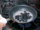 Cooking Class - New England Seafood Specialties in Northern Suburbs: A frying pan with blueberries being cooked for a dessert sauce