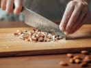 Cooking Class - The Joy of Homemade Paella in Downtown Dallas: Chef cutting almonds